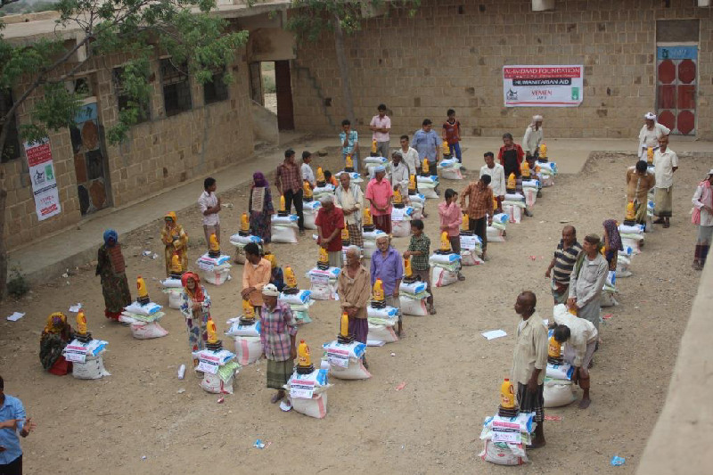 Elderly men from the Wusab governorate collect food hampers for their families